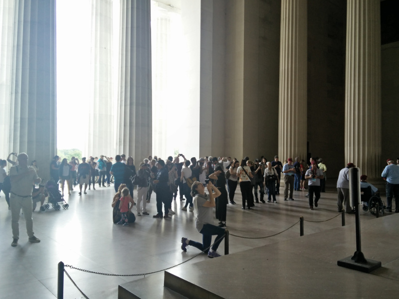 A crowd of people photographing the Lincoln memorial